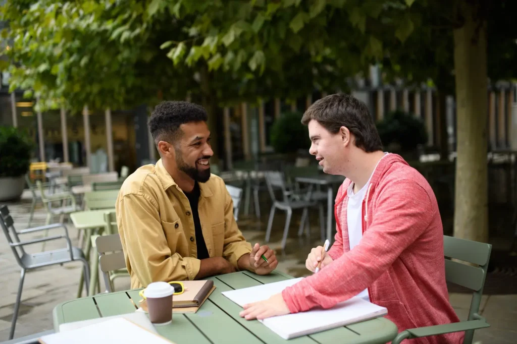 Disabled man and support worker talking